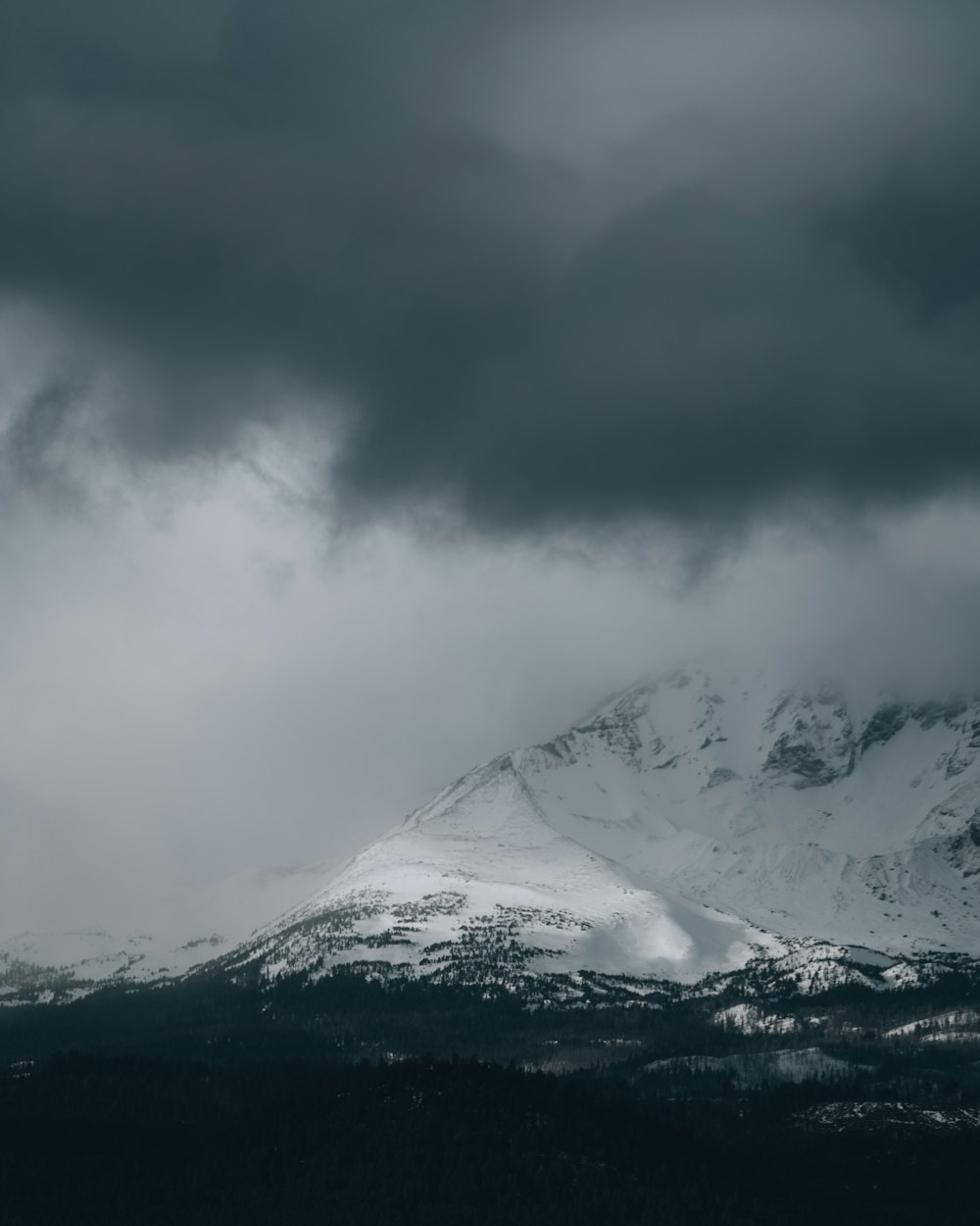 snow covered mountain under cloudy sky during daytime