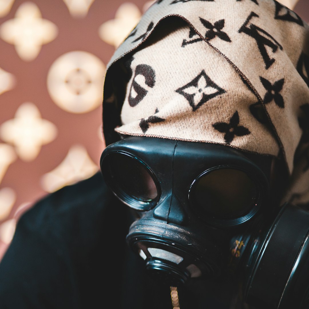 person wearing black and white knit cap and gas mask