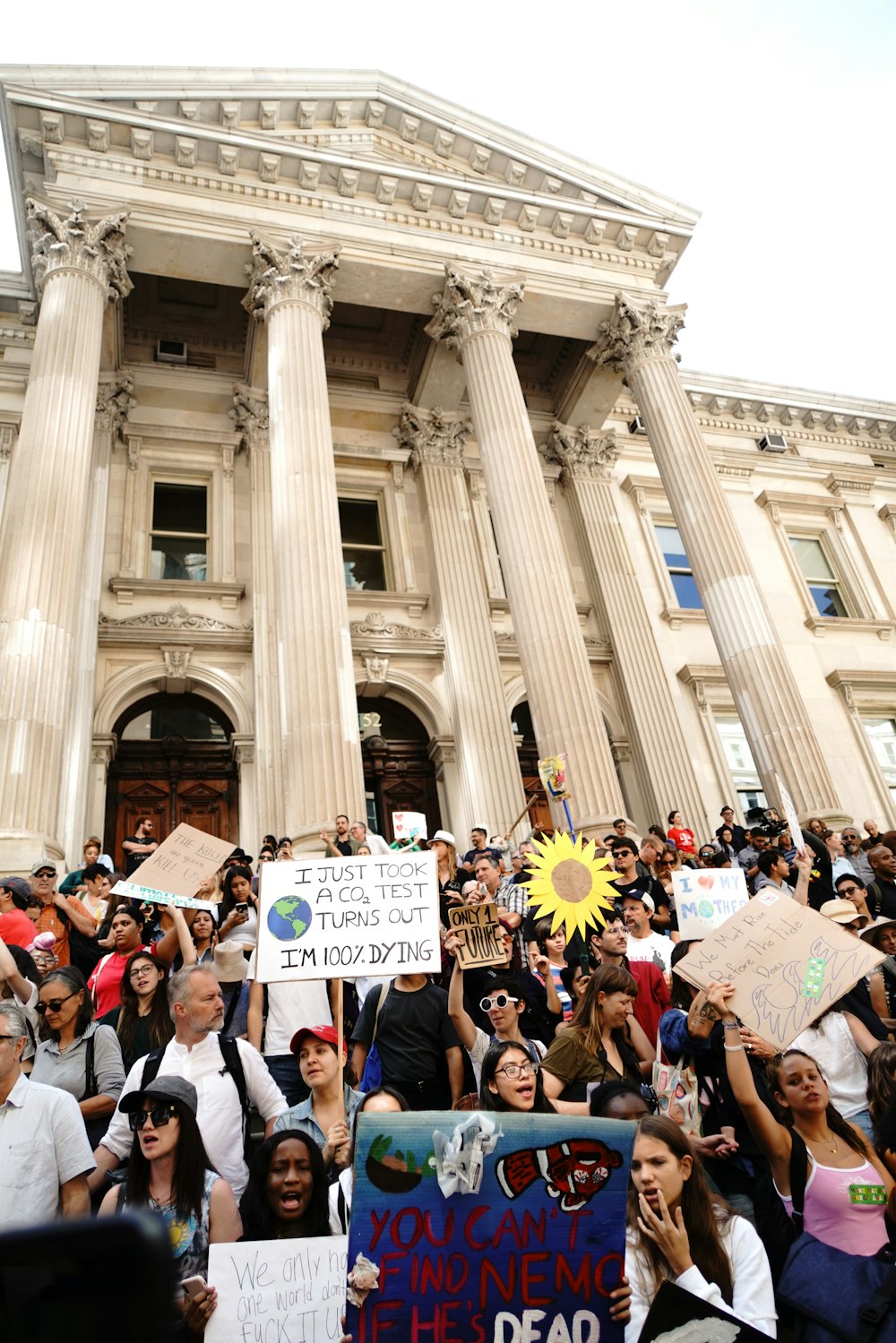 people gathering in front of white concrete building during daytime