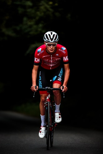 man in red and black bicycle suit riding on black and red bicycle