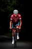 man in red and black bicycle suit riding on black and red bicycle