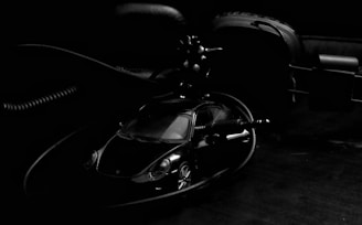 Artistic shot of a 1:64 scale miniature luxury sports car on a textured dark background with soft spotlight