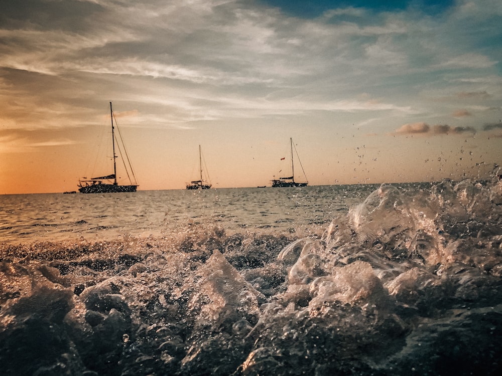 grayscale photo of sail boat on sea shore