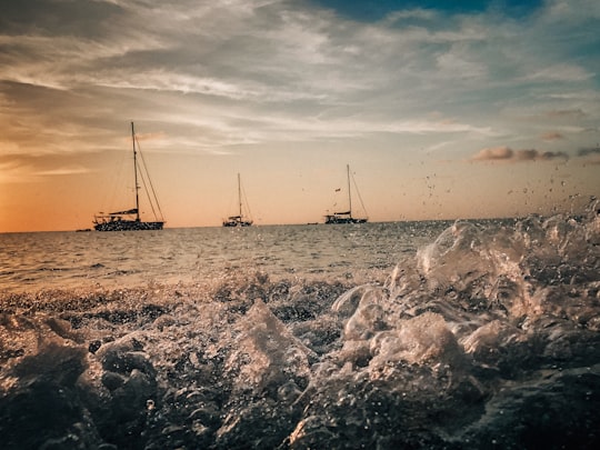 grayscale photo of sail boat on sea shore in Roatán Honduras