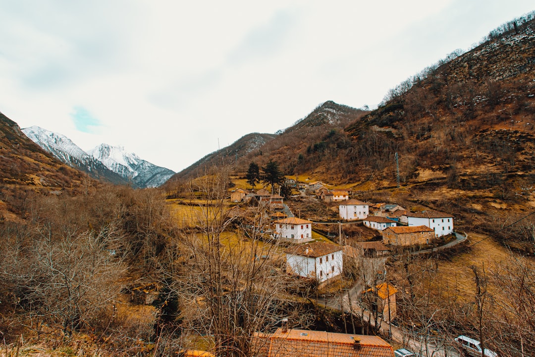 white and brown concrete houses near brown mountain under white sky during daytime