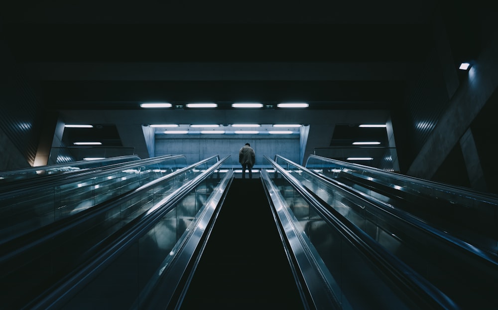 man in black shirt standing on escalator