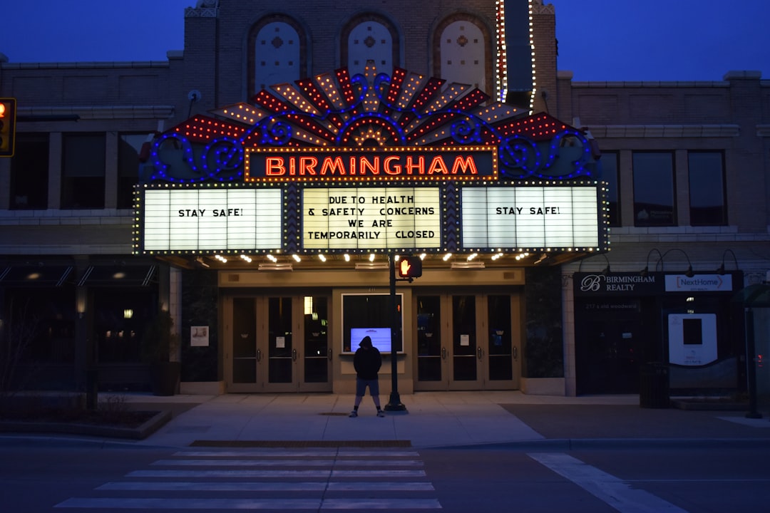 man in black jacket standing in front of brown building