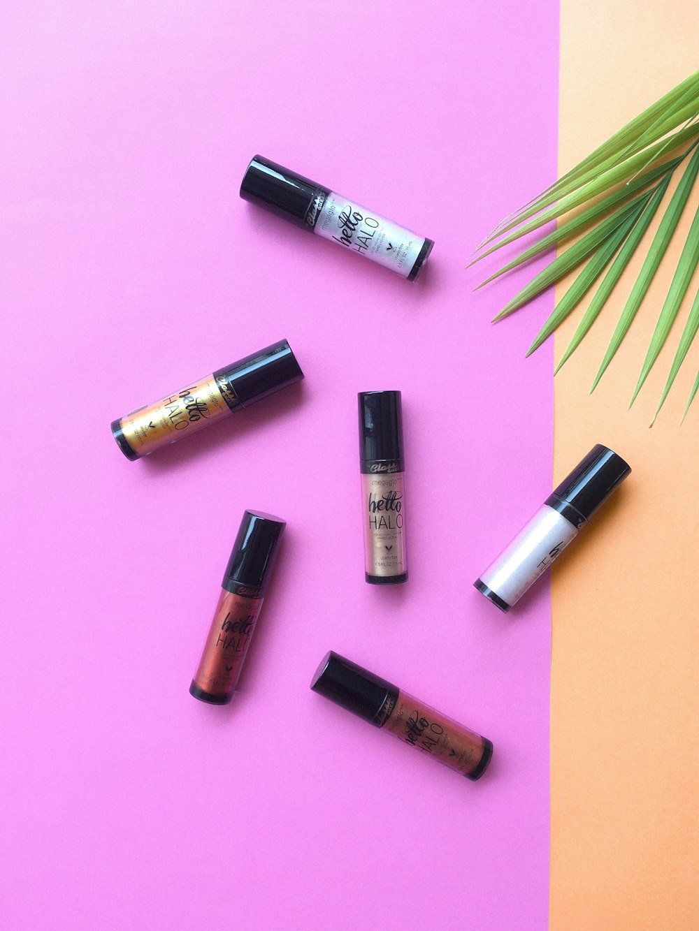 a group of lipsticks sitting on top of a pink and yellow table