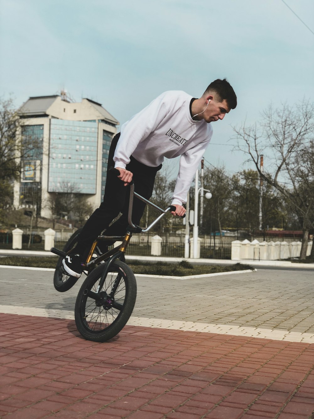 man in white long sleeve shirt riding bicycle on road during daytime