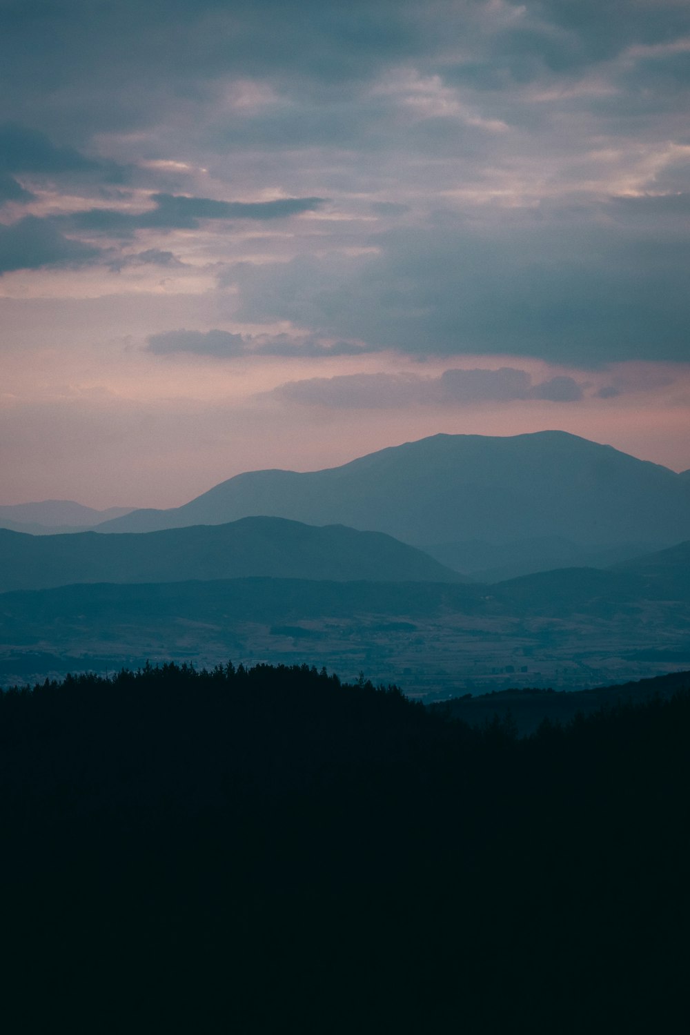 silhouette of mountain under cloudy sky during daytime