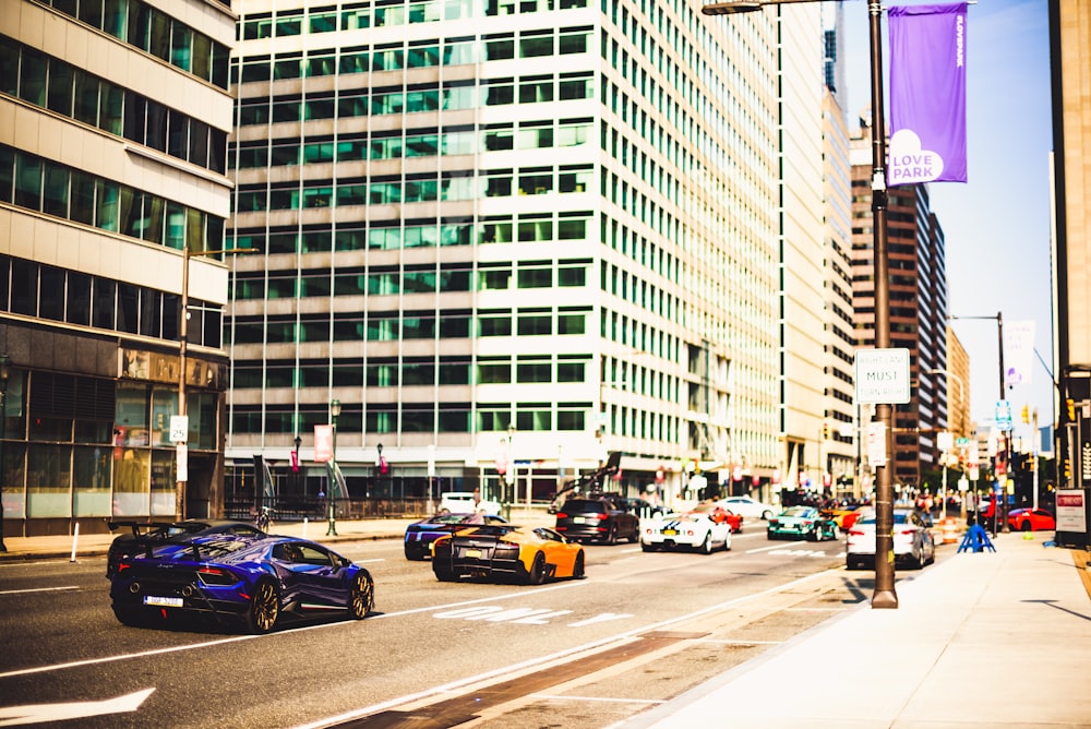 cars parked on side of the road near high rise buildings during daytime