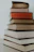 A stack of books with vibrant covers set against a simple black and white backdrop.