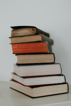 A stack of Andrés Palladino’s books arranged on a wooden table.