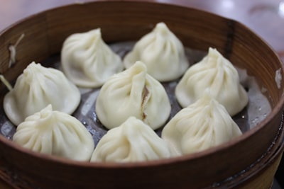 white round food on brown wooden round plate dumpling teams background