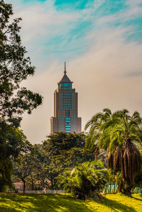 brown concrete building near green trees under blue sky during daytime in Nairobi Kenya
