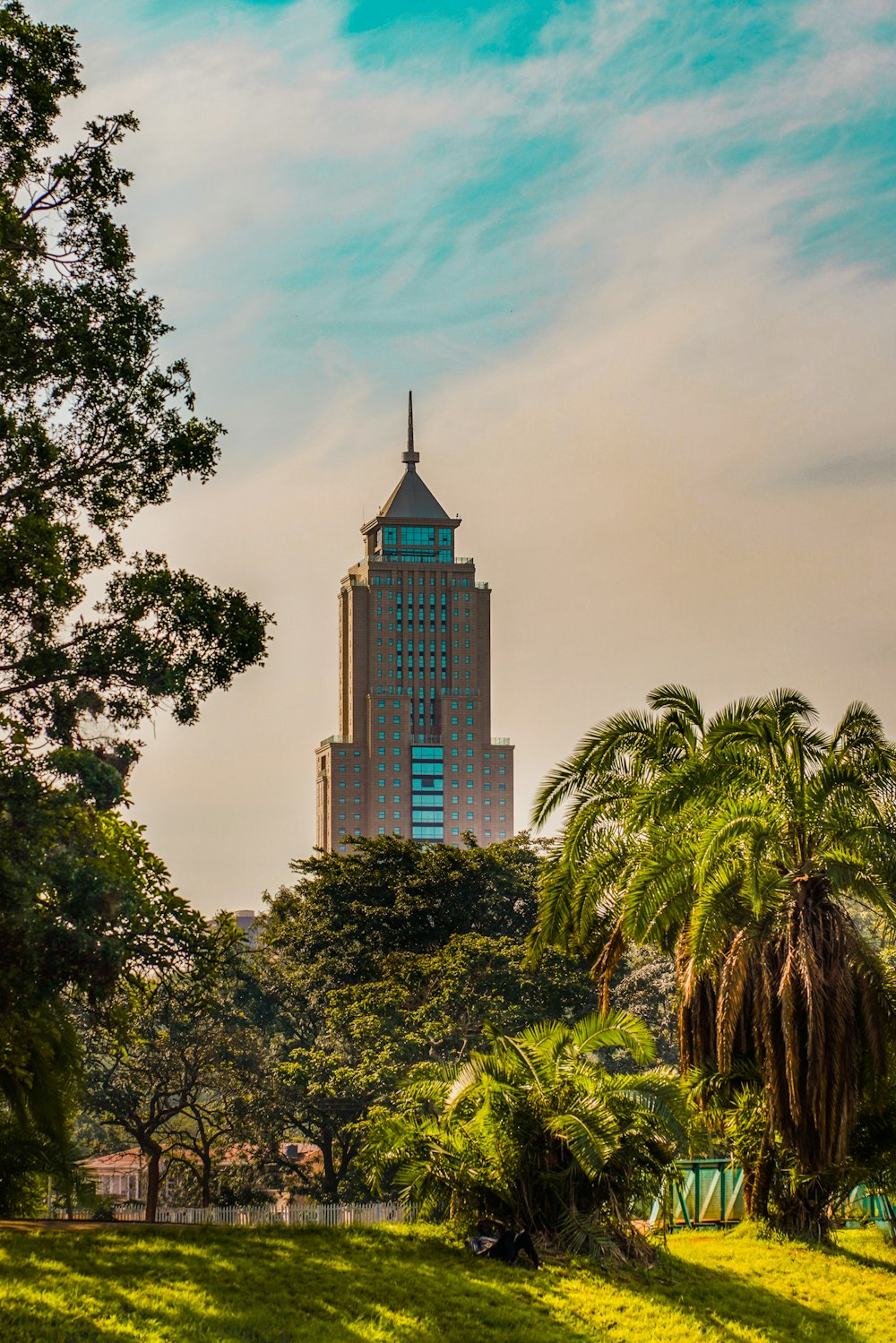 Edificio de hormigón marrón cerca de árboles verdes bajo el cielo azul durante el día