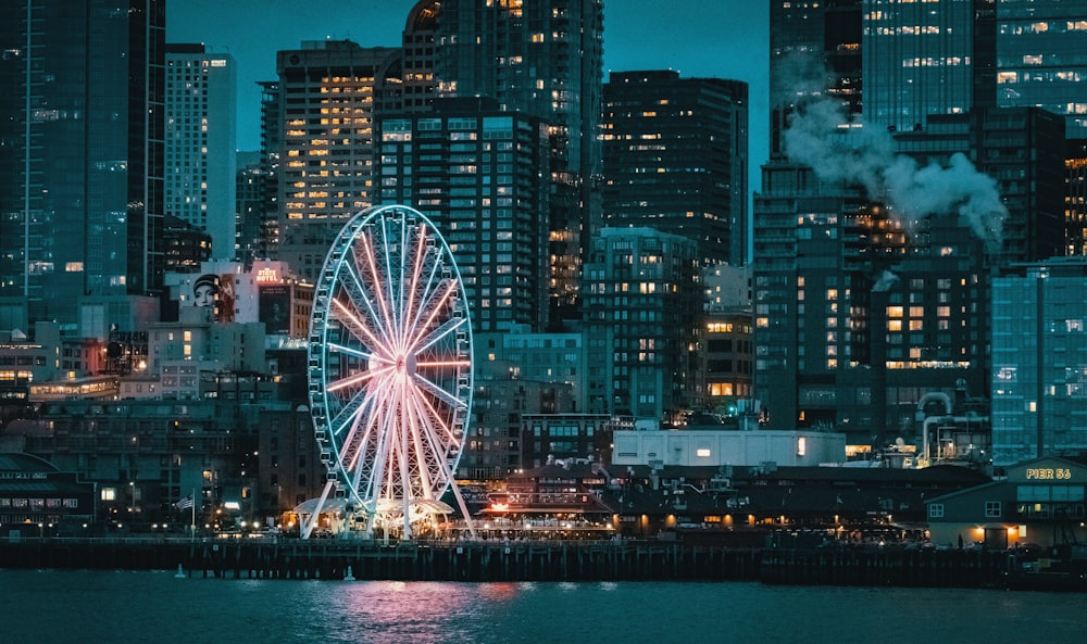 Riesenrad in der Nähe von Stadtgebäuden während der Nachtzeit