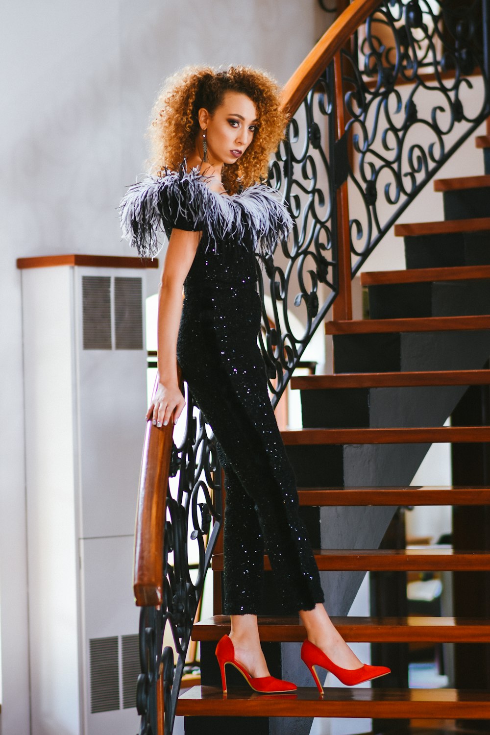 woman in black dress standing on staircase