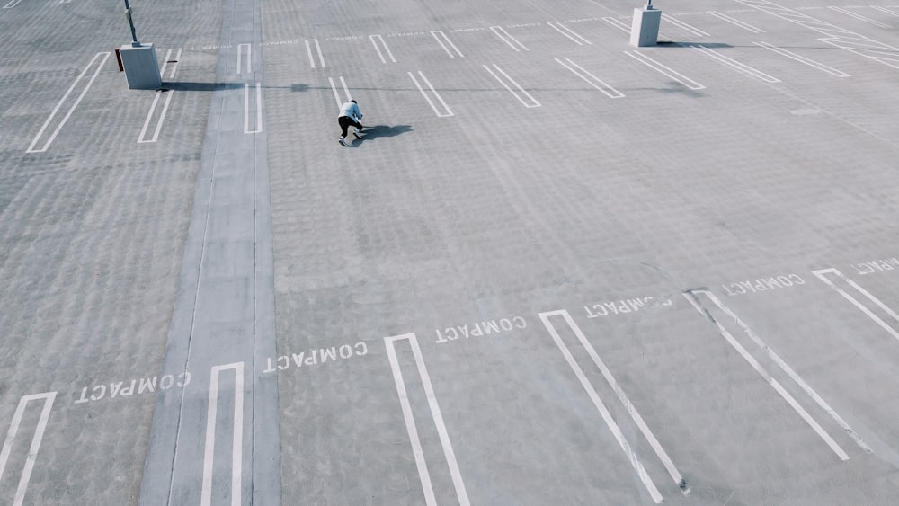 man in black jacket and black pants sitting on gray concrete floor during daytime