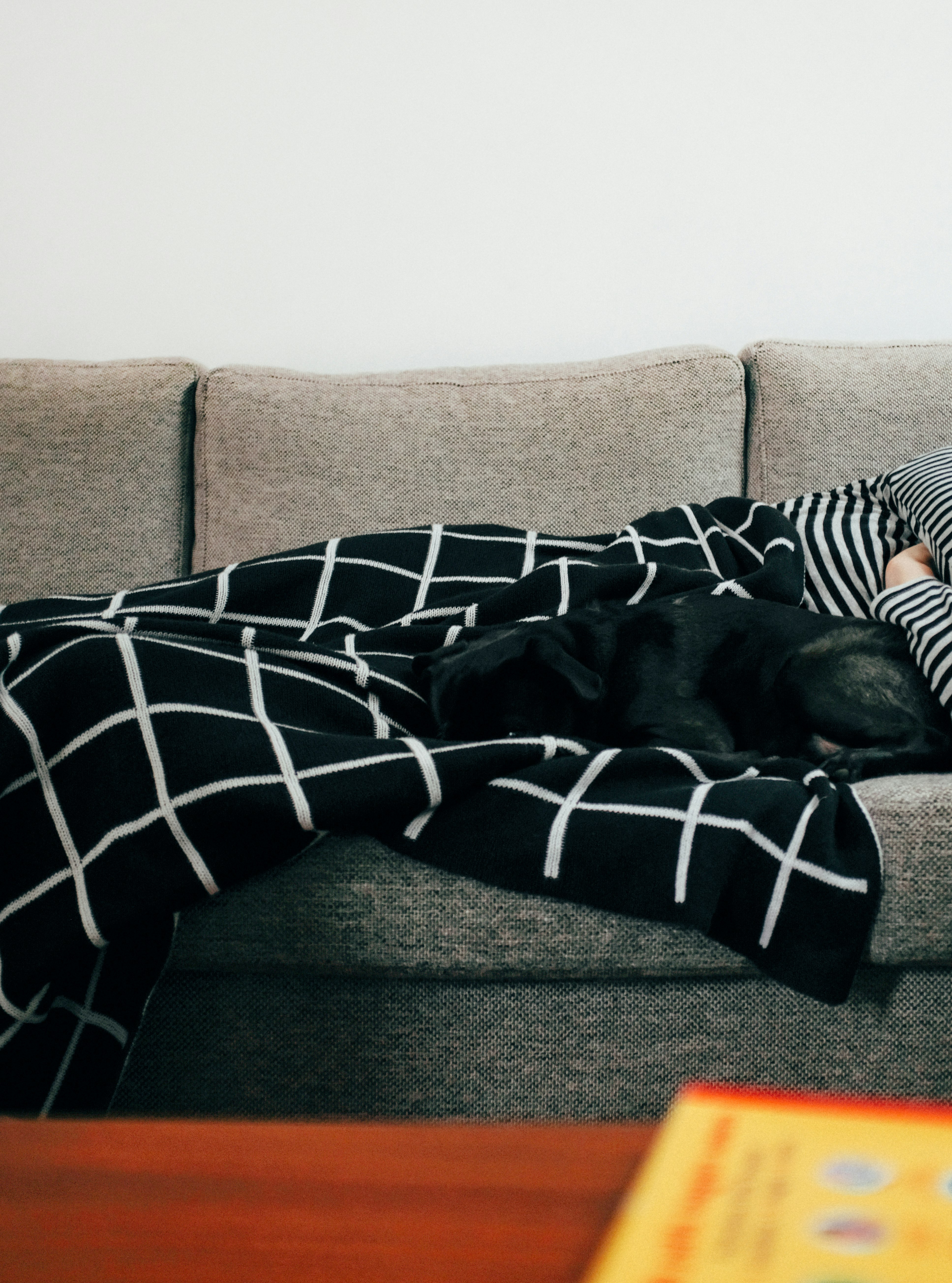 person in black and white striped pants lying on brown couch