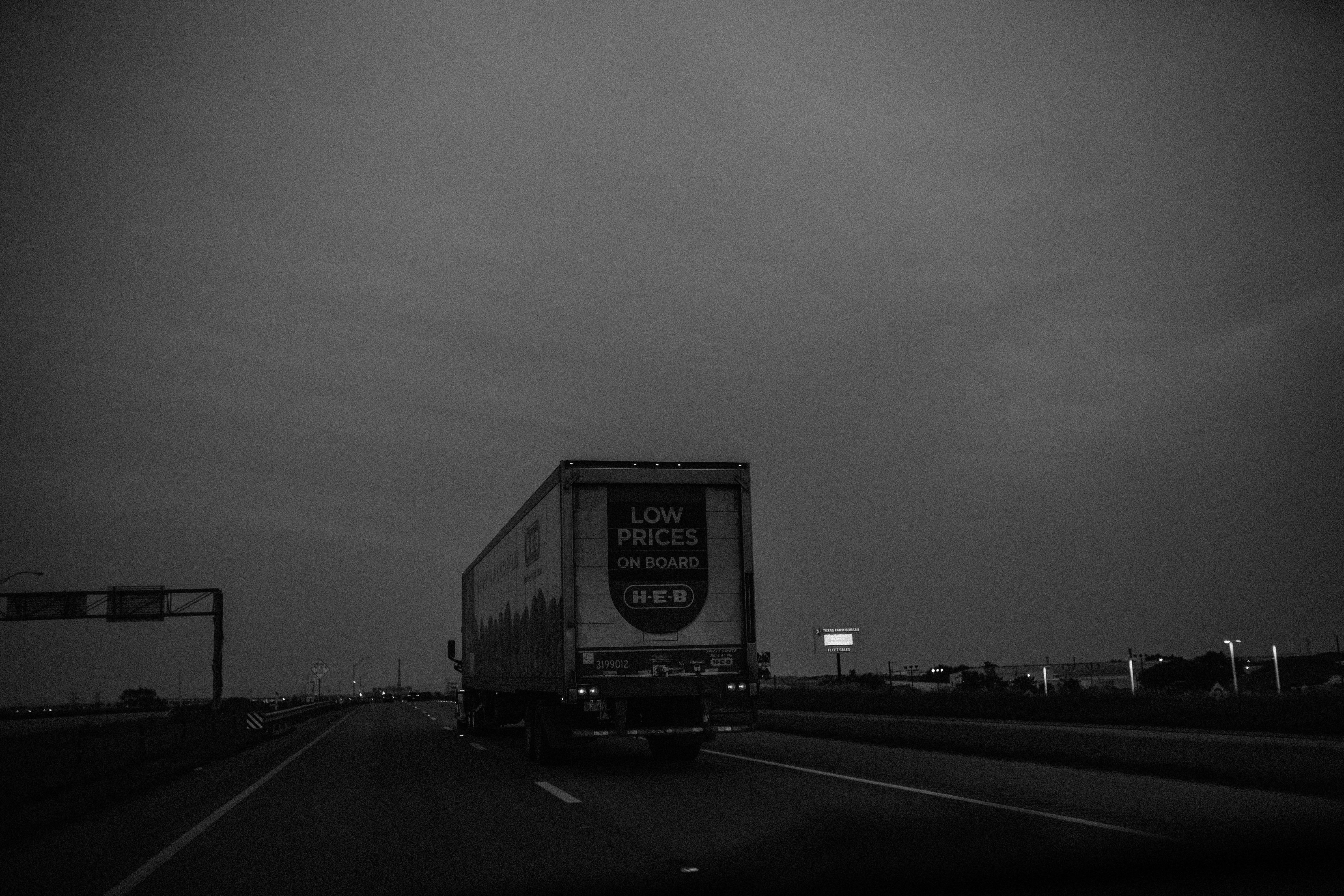 grayscale photo of a truck on a road