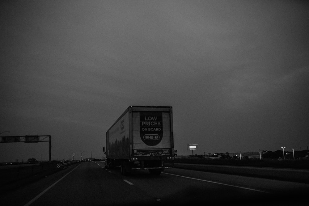 grayscale photo of a truck on a road