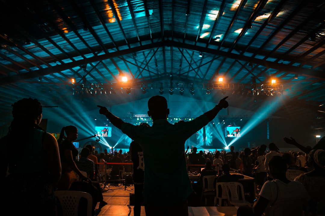 man in black jacket standing on stage, Worship
