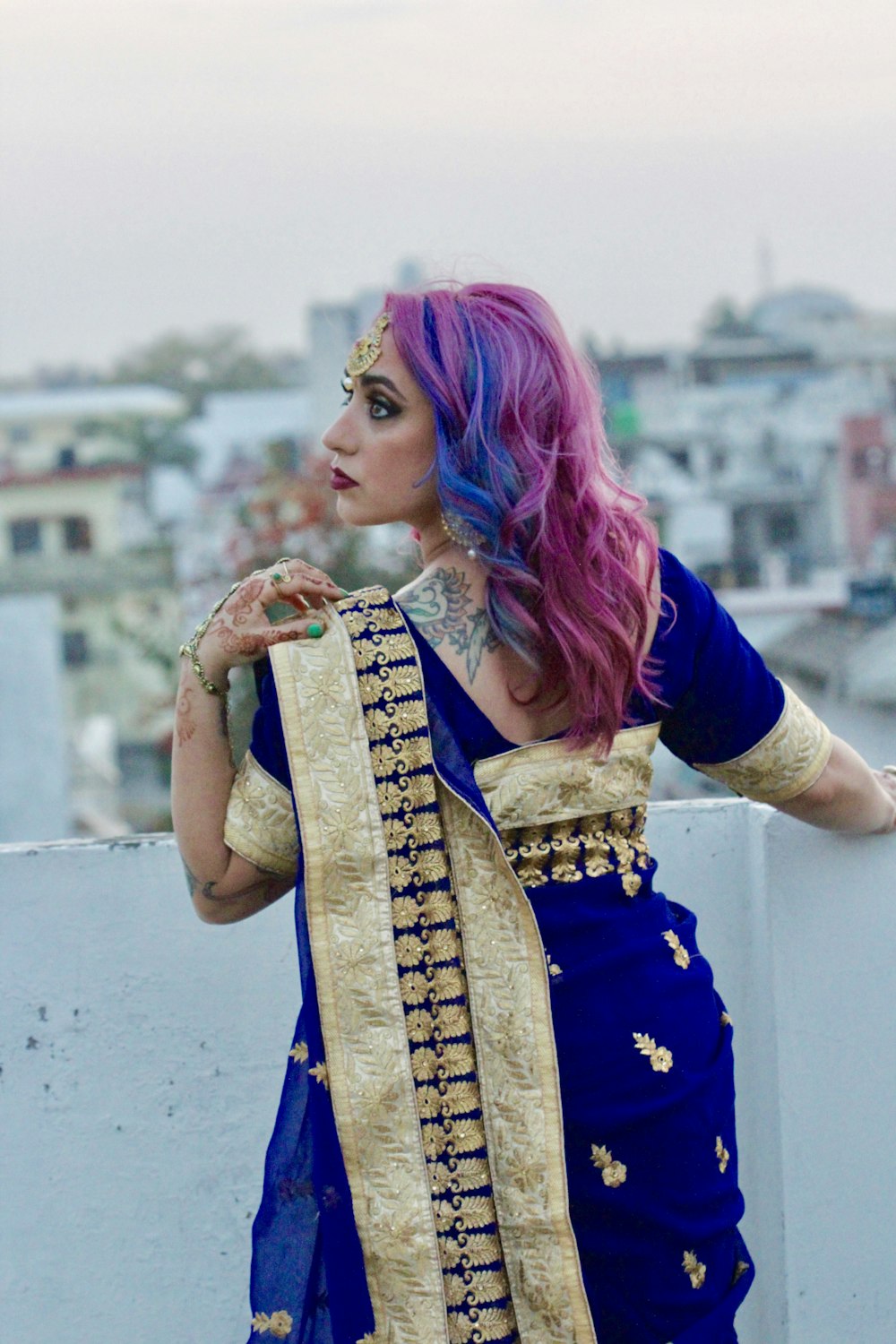 woman in blue and gold sari standing and smiling