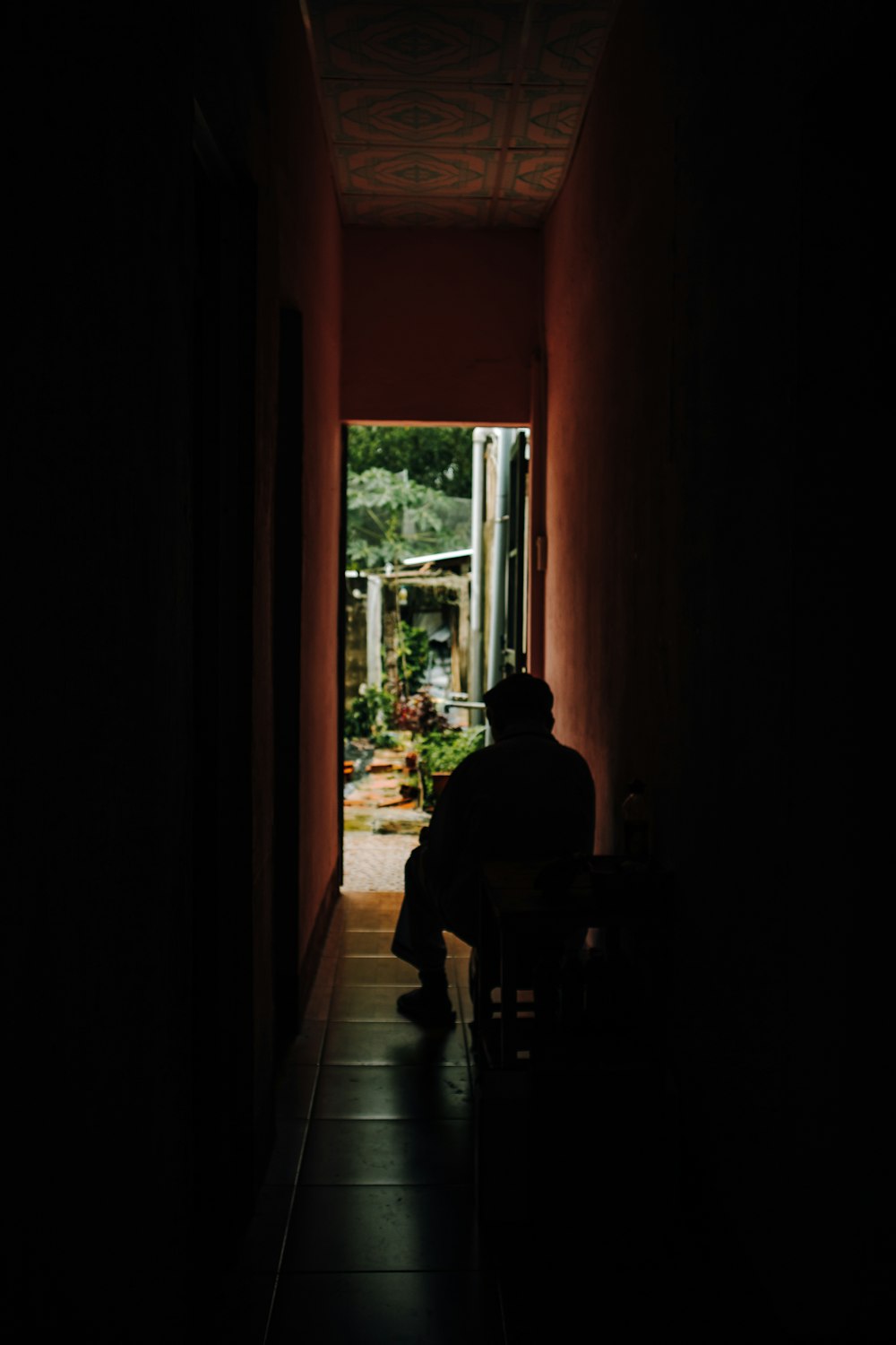 man in black shirt sitting on chair near window during daytime