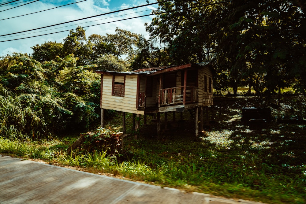 brown wooden house near green trees under blue sky during daytime