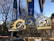 Three Boston Marathon medals are hanging against a backdrop of a clear blue sky and bare trees. Each medal features a unicorn emblem and the words 'Boston Athletic Association.' The medals are adorned with blue and yellow ribbons, showcasing different years of the marathon events.