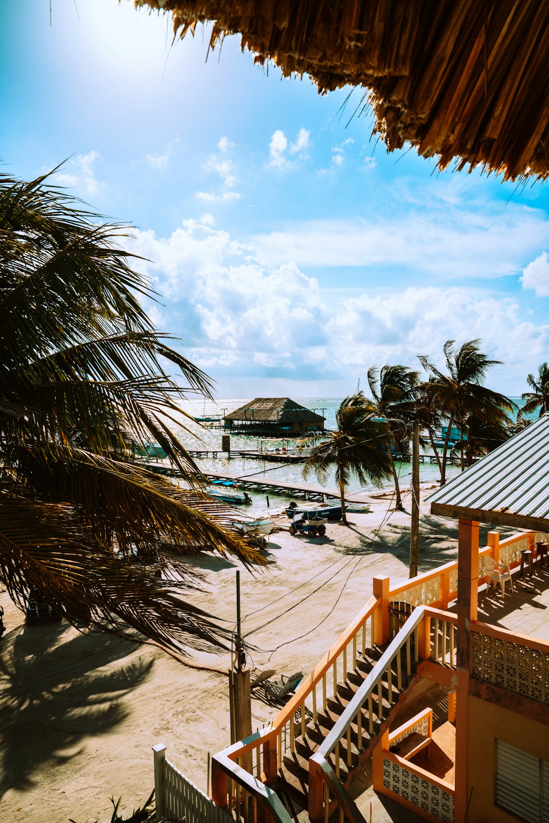 brown wooden staircase near green palm trees during daytime