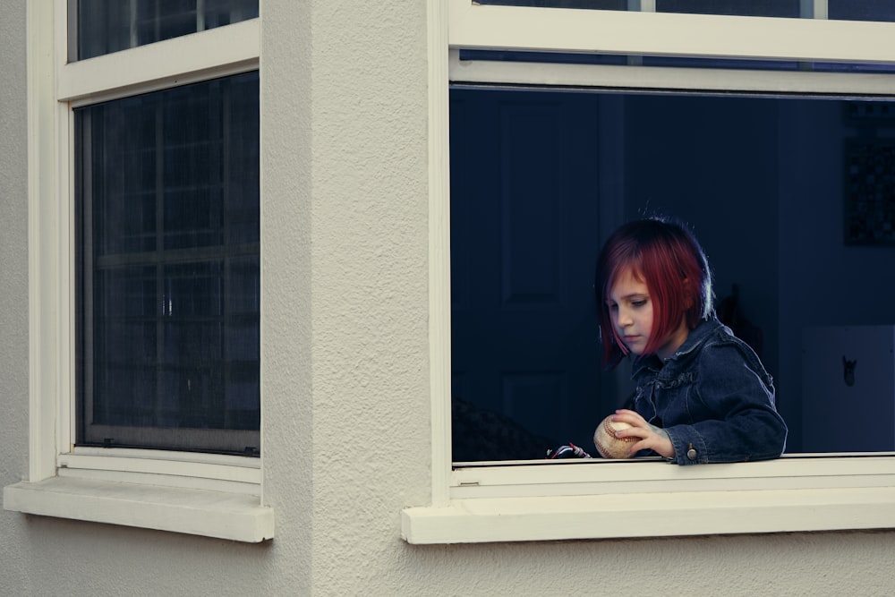 woman in black jacket sitting beside window