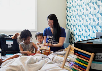 woman in gray crew neck t-shirt sitting on bed