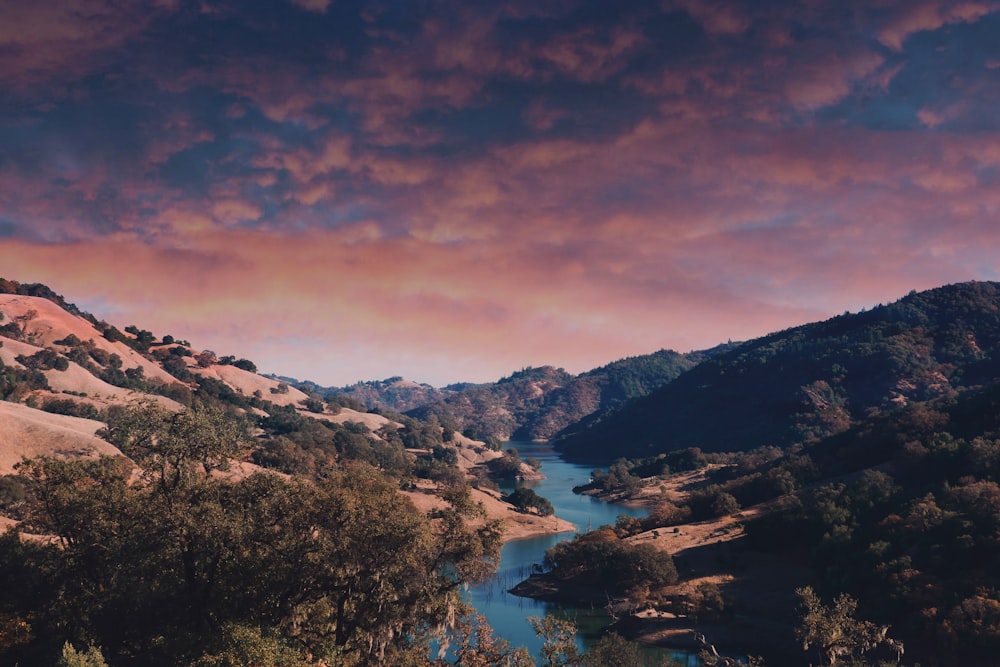 lake in the middle of mountains during sunset