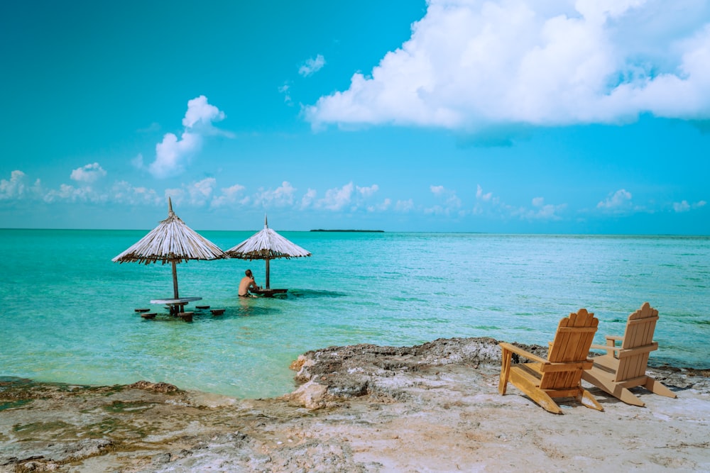 brown wooden lounge chairs on beach during daytime