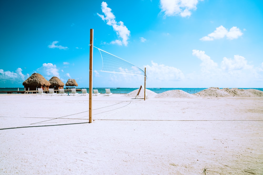 white and blue net on white sand during daytime