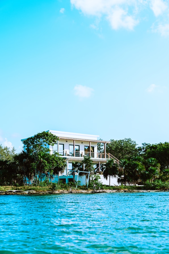 white concrete building near green trees and body of water during daytime