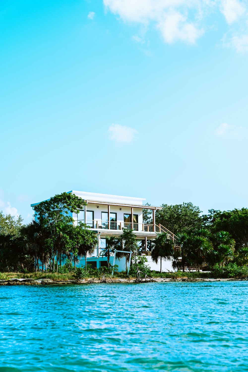 white concrete building near green trees and body of water during daytime