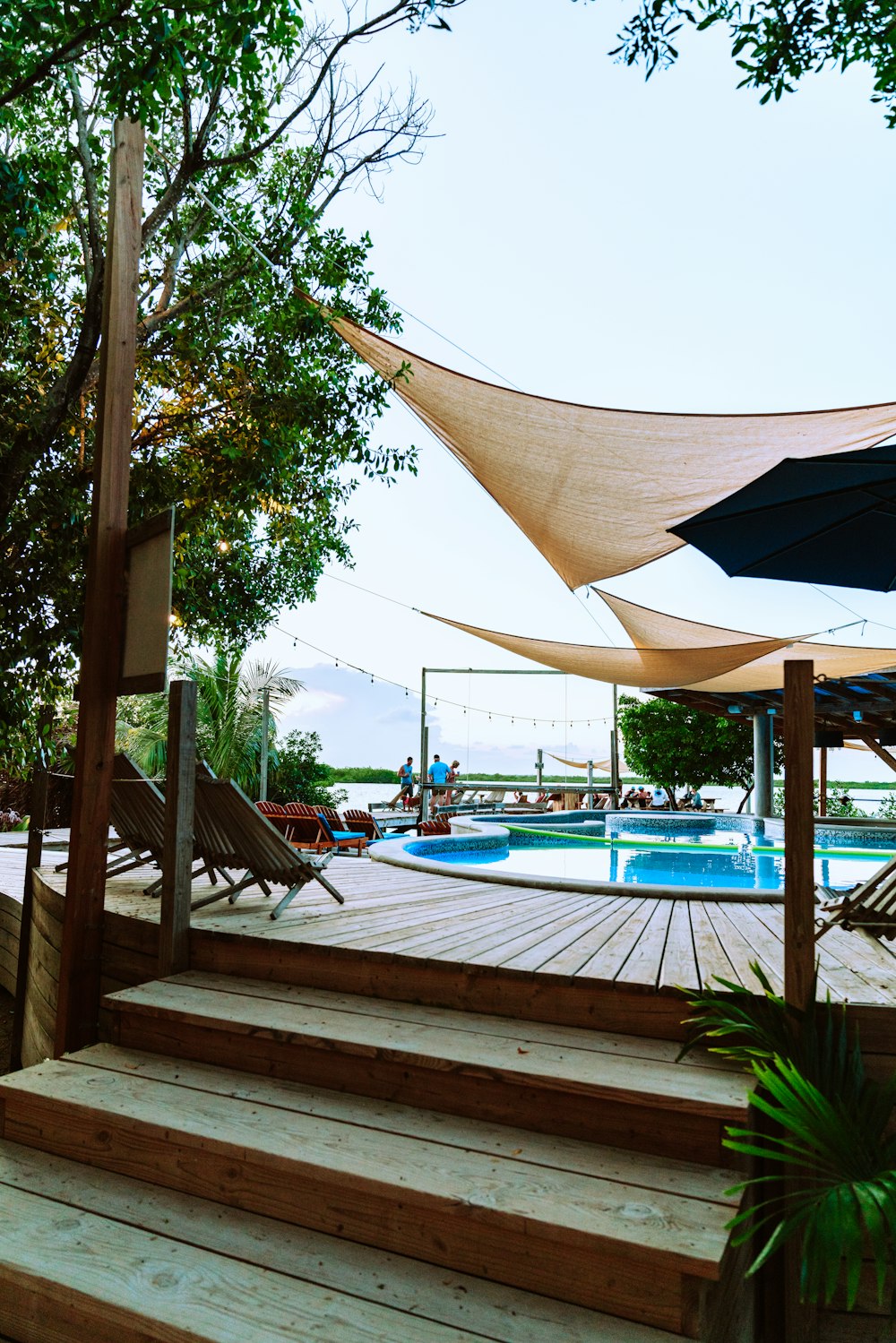 brown umbrella near swimming pool