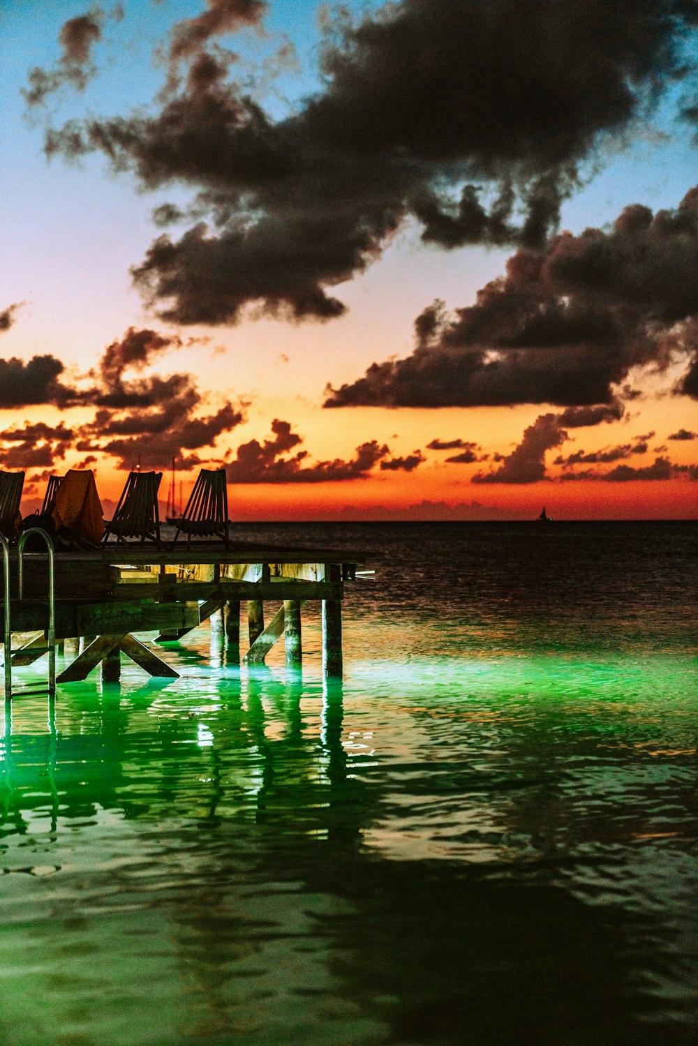 brown wooden dock on sea during sunset