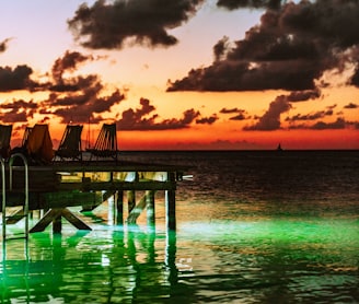 brown wooden dock on sea during sunset