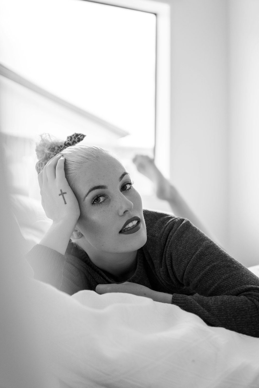 woman in long sleeve shirt lying on bed