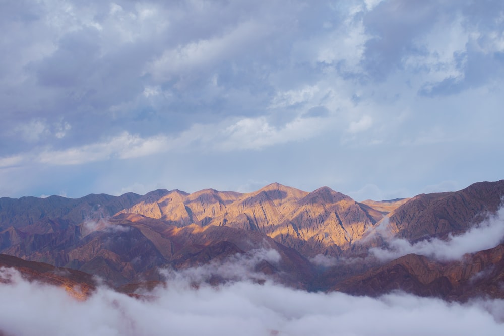 brown mountains under white clouds during daytime