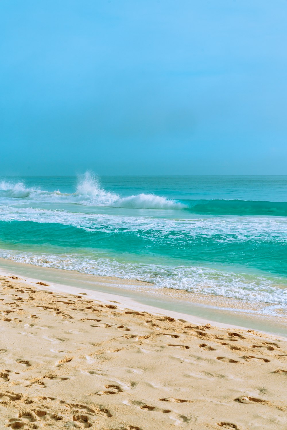 ocean waves crashing on shore during daytime