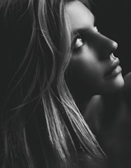 A sophisticated portrait of Rose Peter Graham in a dark charcoal setting with soft gold lighting highlighting her composed expression.