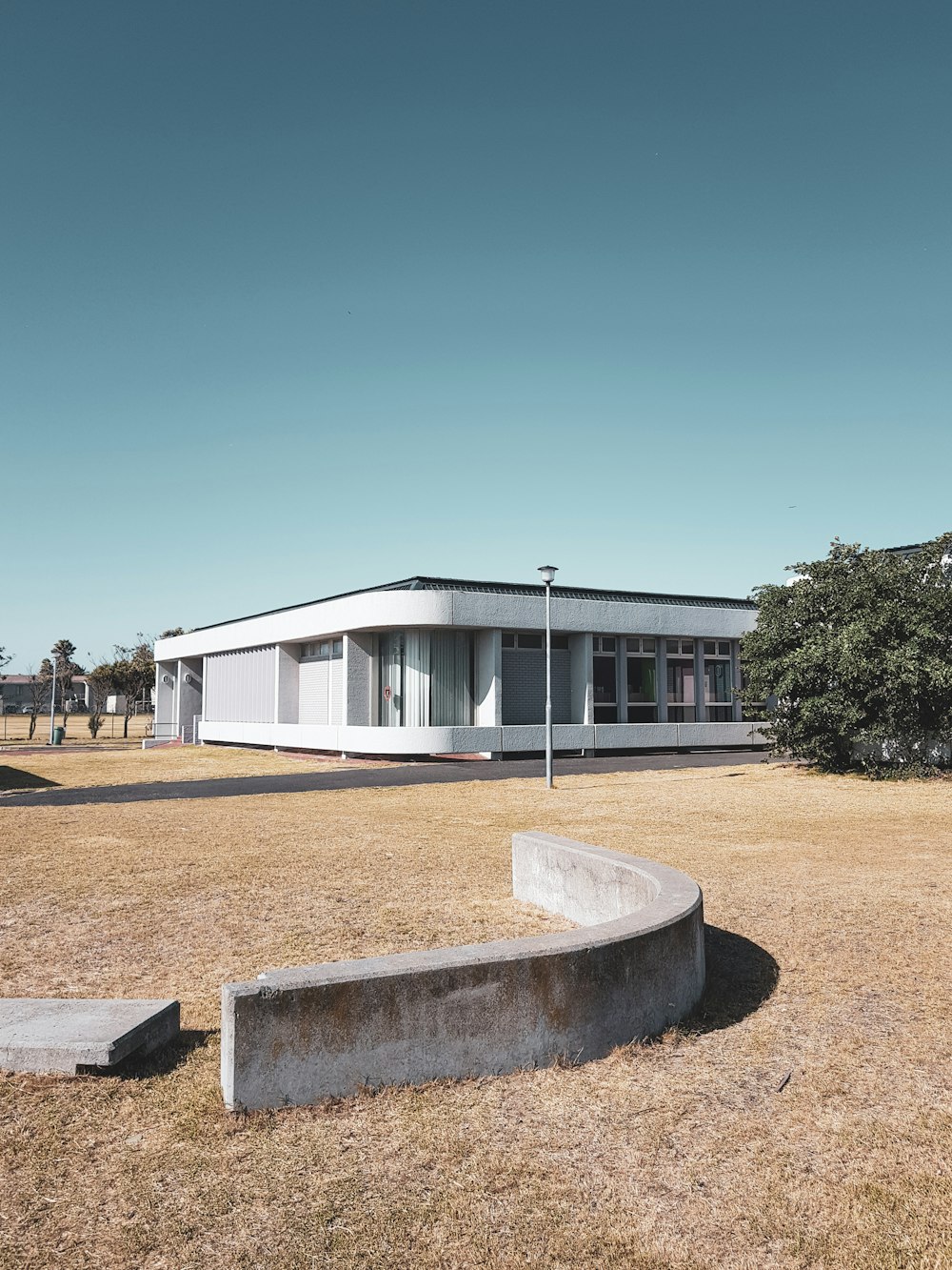 white concrete building near green trees under blue sky during daytime