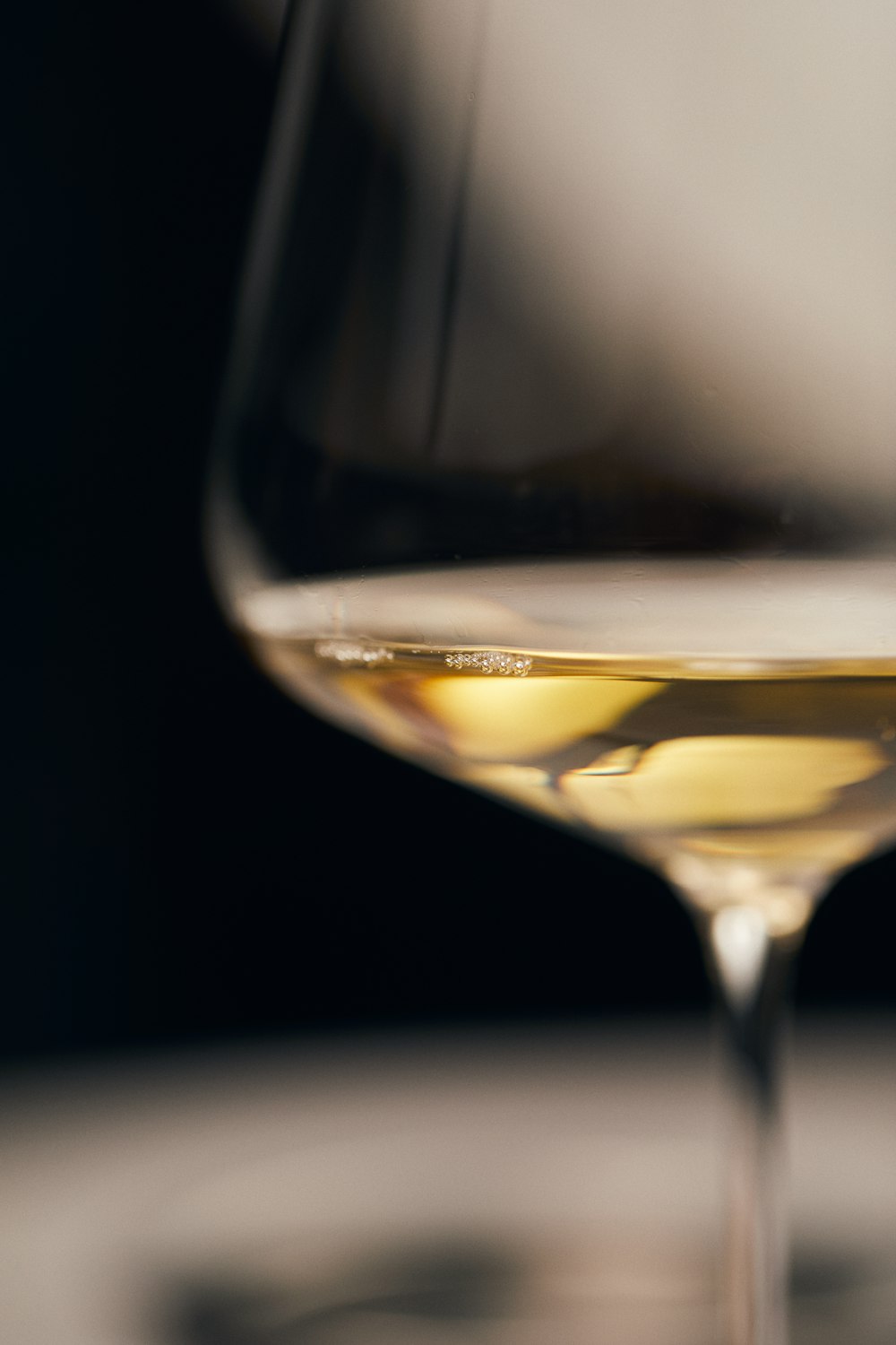 copo de vinho transparente com líquido amarelo