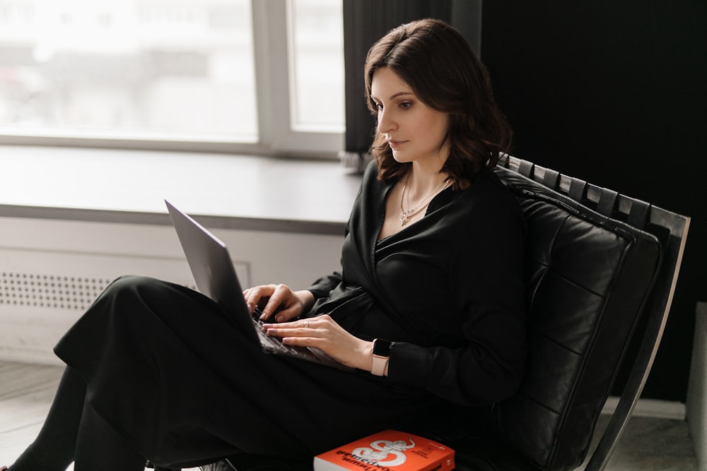 MacBookを使用した黒い長袖シャツの女性