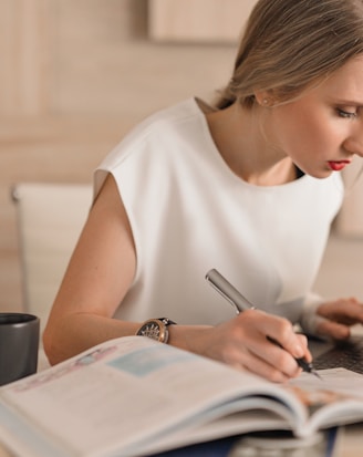 woman in white crew neck t-shirt using silver macbook